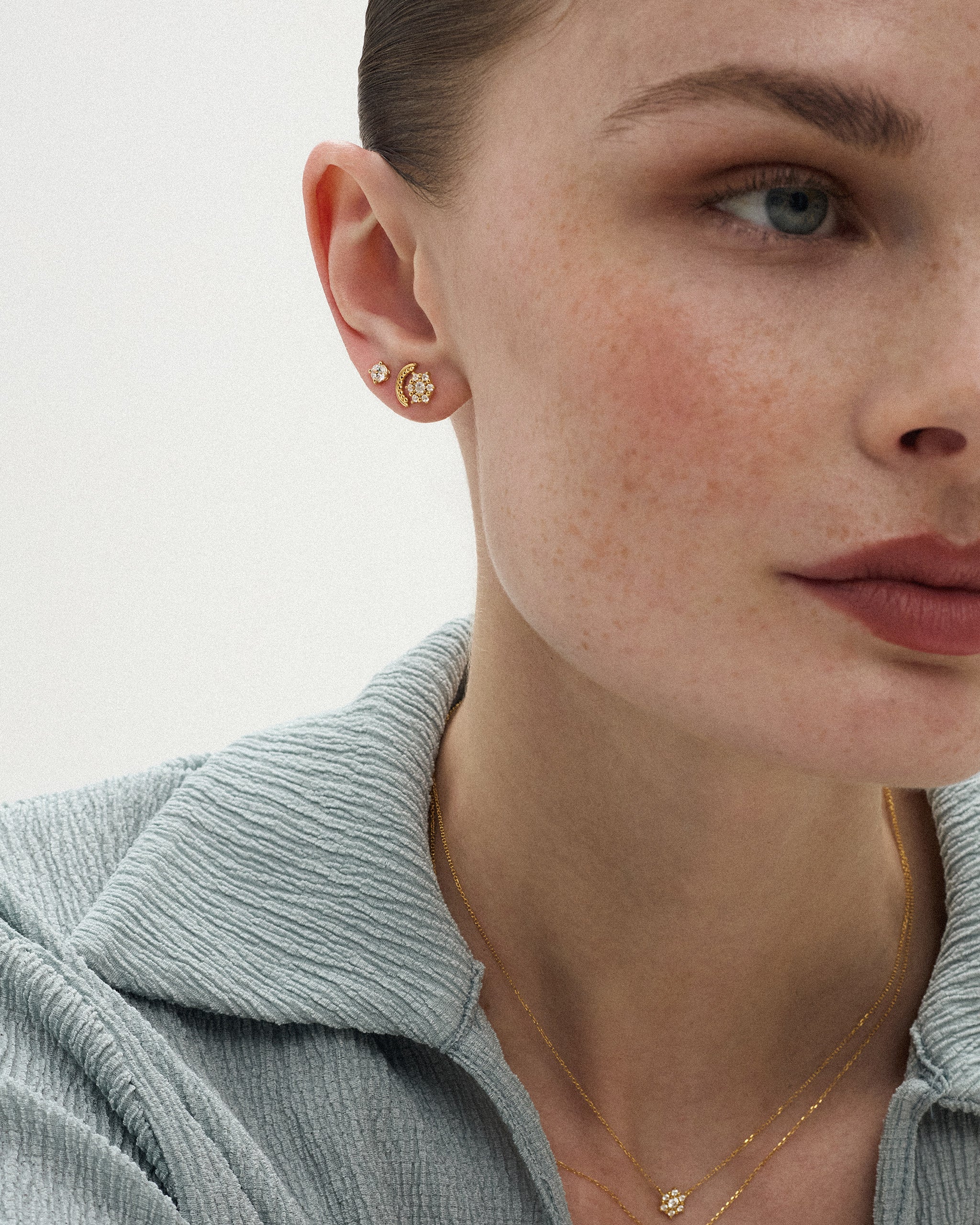 Woman wearing the Selas Diamond Cluster Studs in 14k yellow gold with the matching Selas Diamond Necklace, showing the 7.3mm cluster at true scale. ENEA Studio