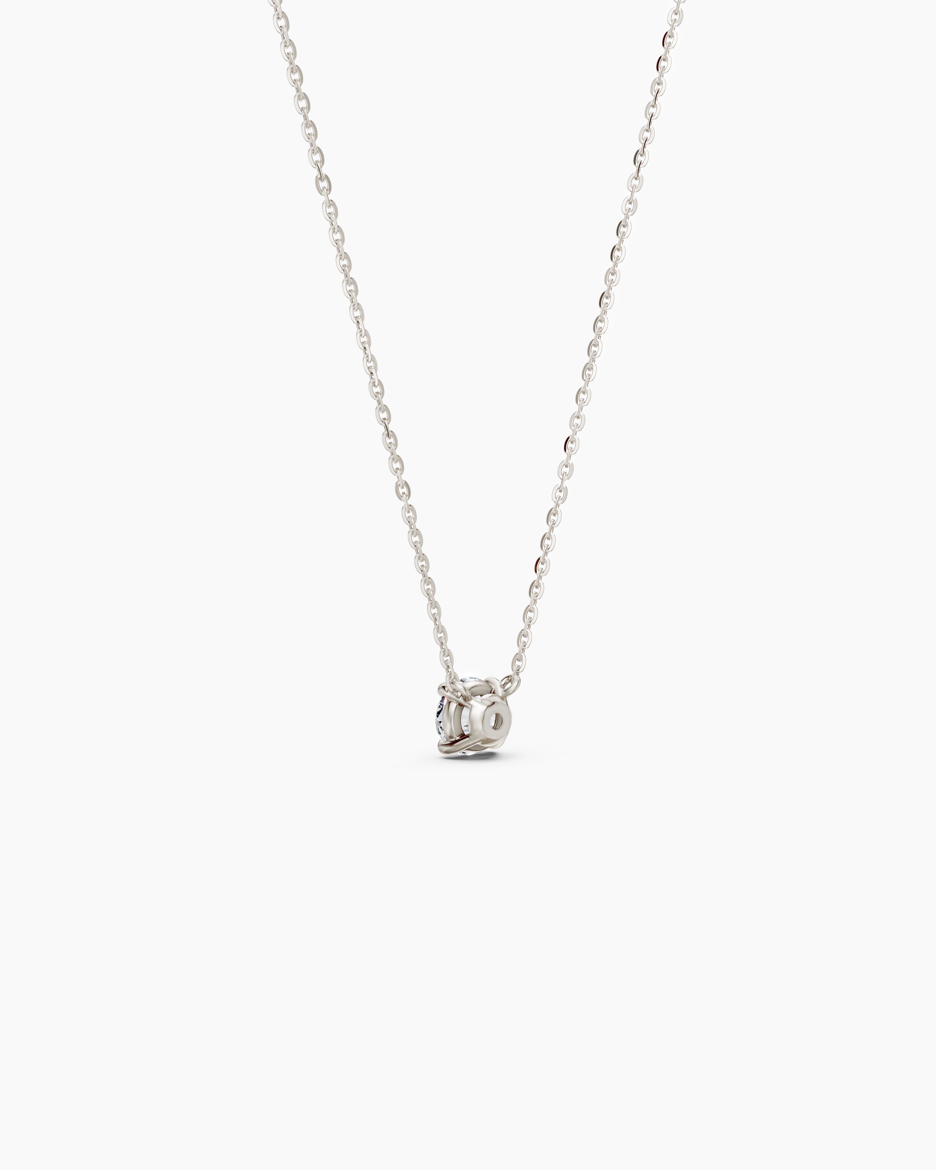 Back view of a white gold necklace with a round diamond pendant on a soft beige background