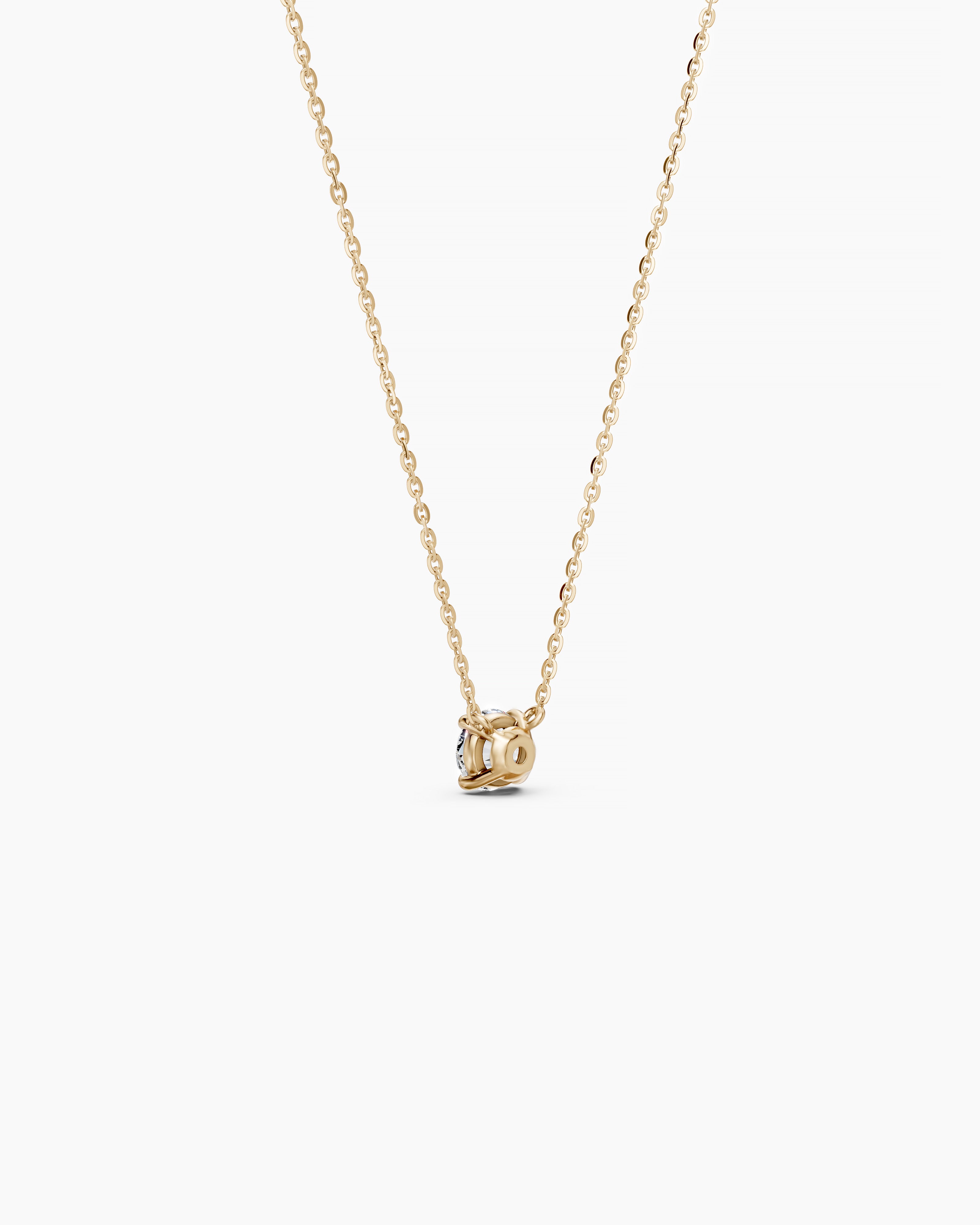 Back view of a yellow gold necklace with a round diamond pendant on a soft beige background