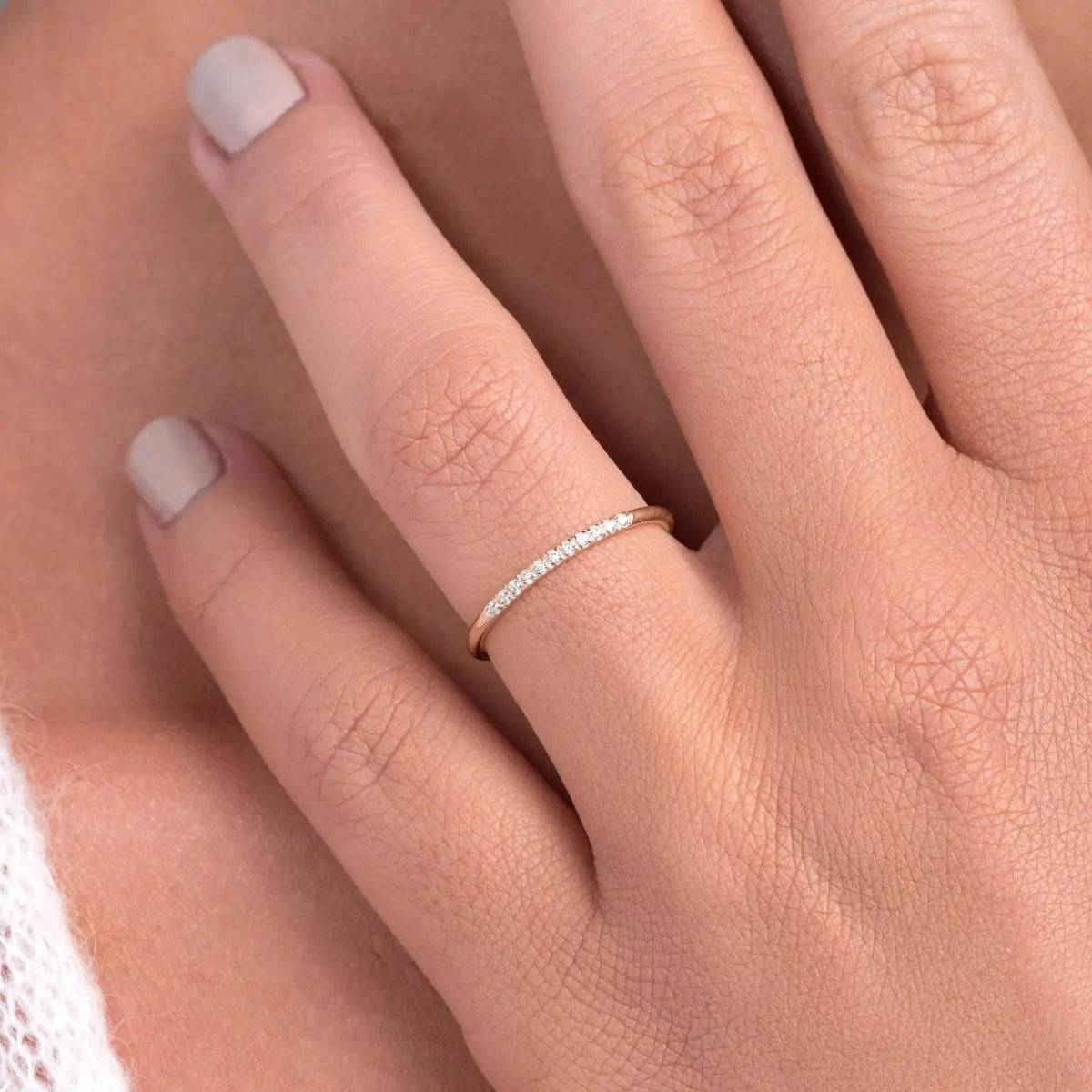 14k rose gold thin pave diamond stacking band ring worn on model hand, close up showing delicate diamond ring on finger