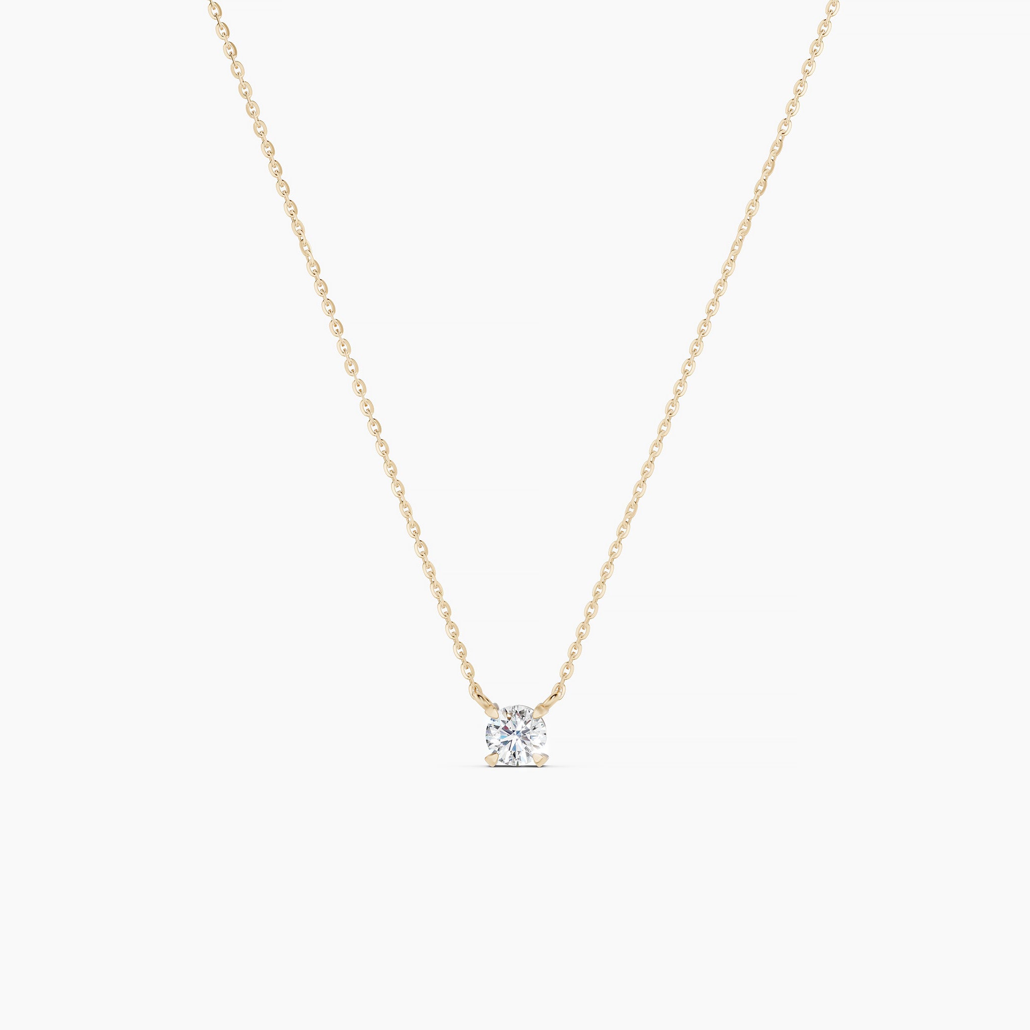 Gold necklace with a diamond pendant on a grey background