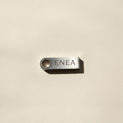 Metallic USB stick with 'ENEA' text on a beige background.