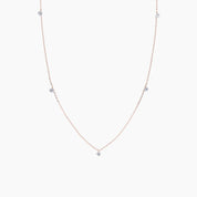 Delicate necklace with small diamonds on a light pink background