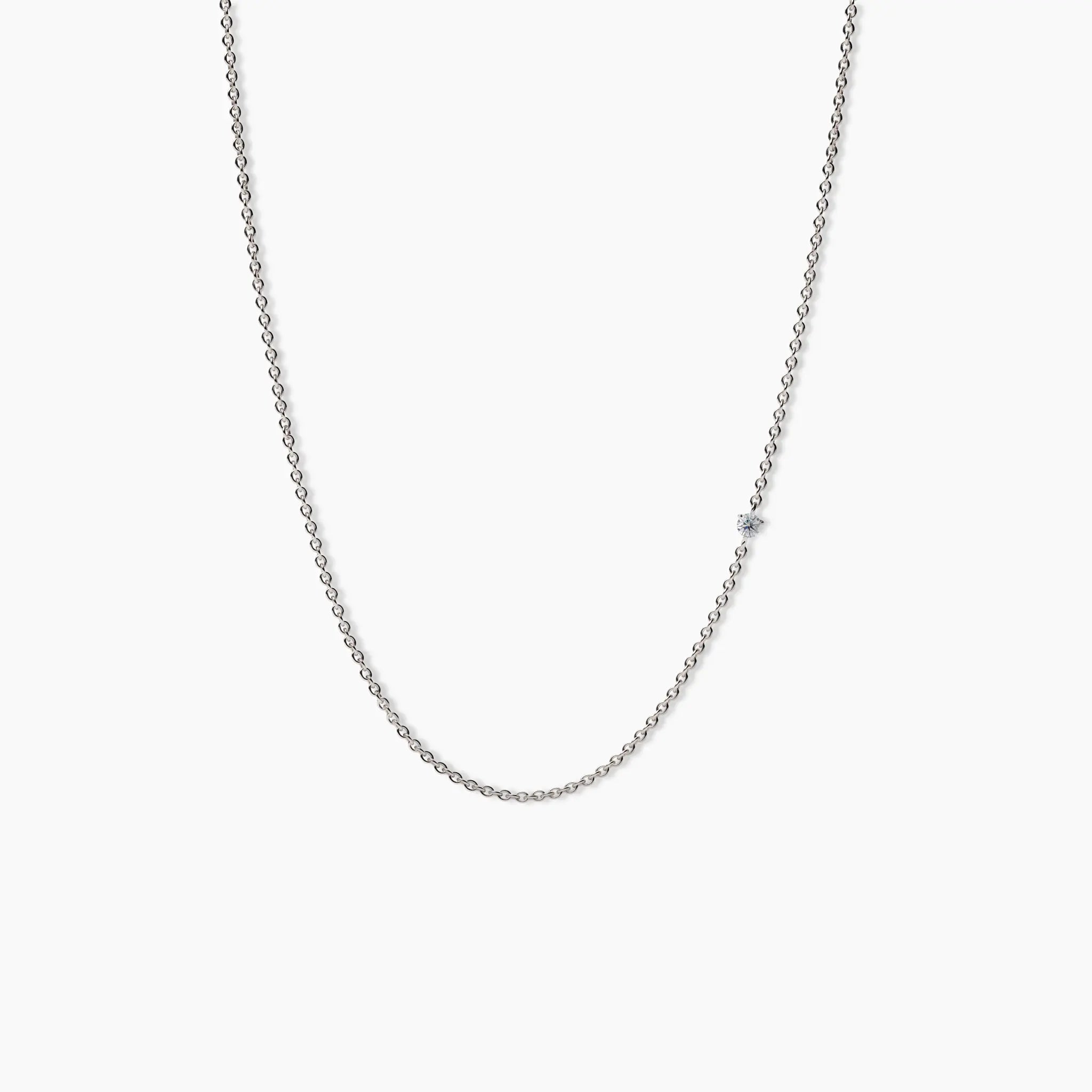 Minimalist white gold necklace featuring a single small diamond set along a fine chain, displayed against a clean white background.
