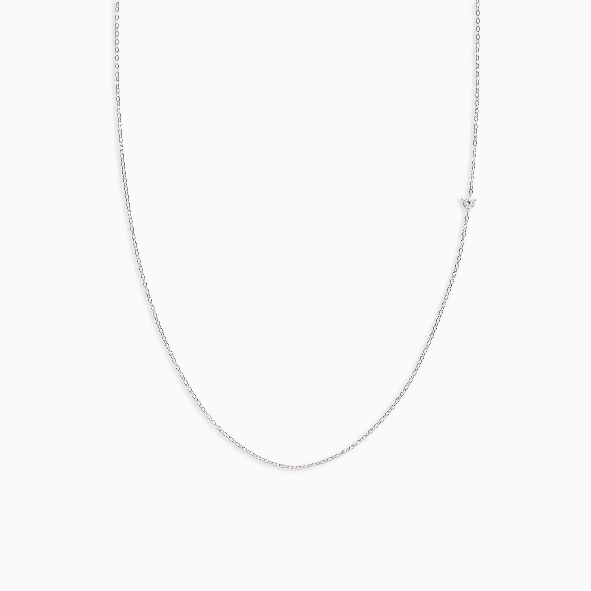 white gold chain diamond necklace on a light gray background