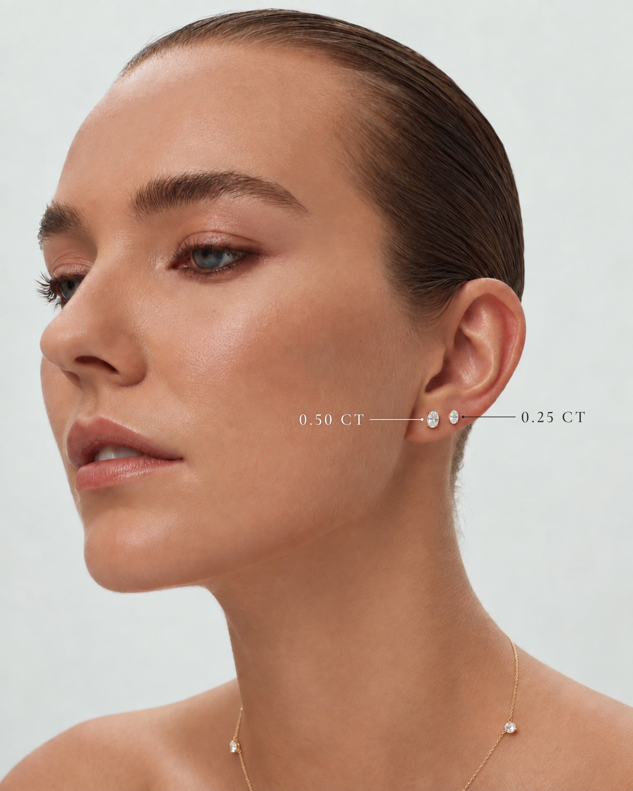 Model wearing oval lab diamond studs in 14k yellow gold, 0.50 ct and 0.25 ct each, labelled, ENEA Studio