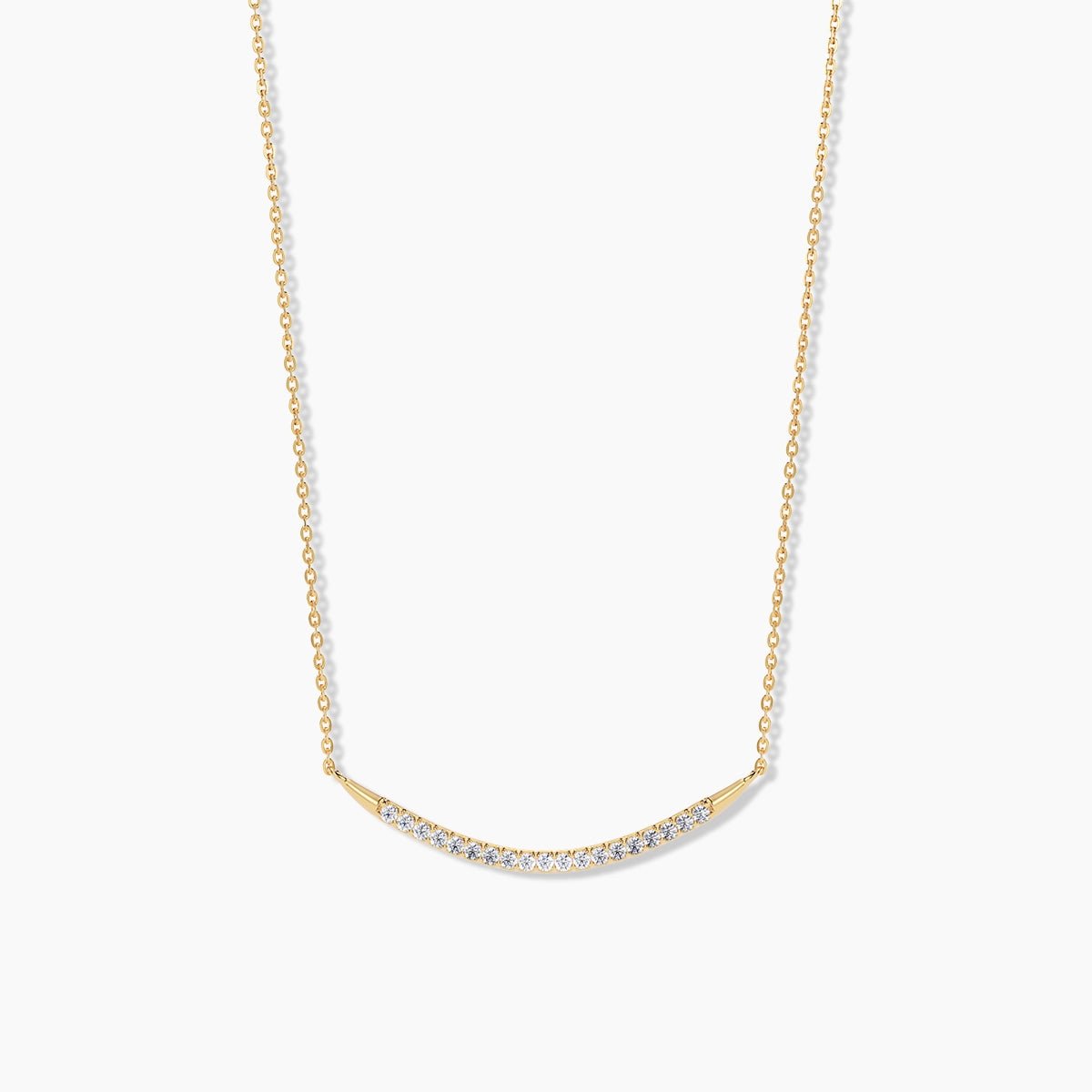14k yellow gold curved bar necklace with pavé diamonds, shown on a white background to highlight the delicate arc and sparkle.
