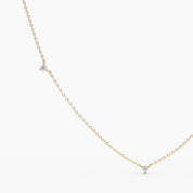 Close-up view of a delicate yellow gold necklace featuring tiny round diamonds evenly spaced along a fine chain.
