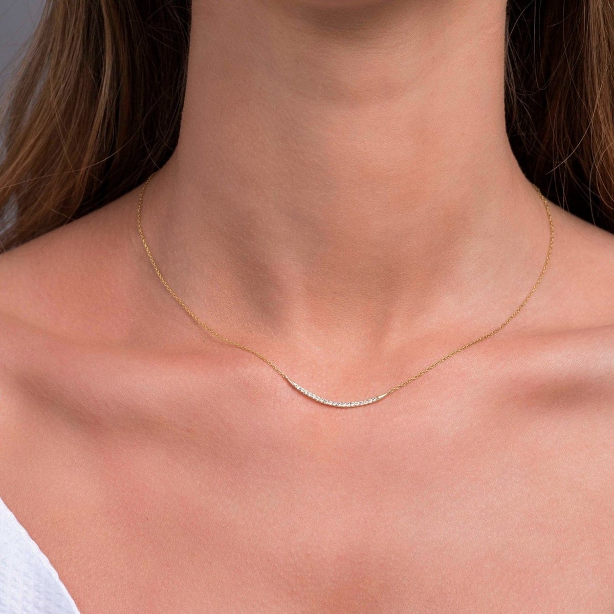 Yellow gold pavé bar necklace shown on model, highlighting its elegant curve and minimal sparkle.