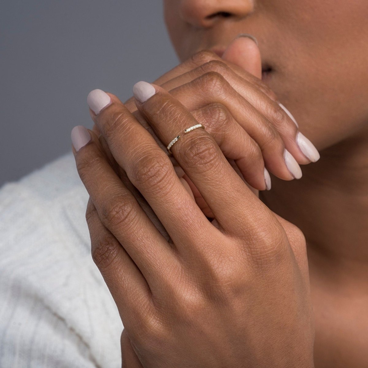 close-up of a model’s hands featuring the open cuff diamond ring in yellow gold as a centerpiece
