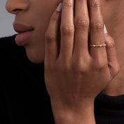 Close-up of a woman wearing a 14k yellow gold diamond beaded ring, highlighting its intricate gold beadwork and sparkling diamonds. Perfect for stacking or wearing alone.