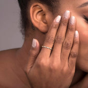 A woman’s hand adorned with a 14k white gold twisted diamond eternity band, emphasizing the fine twisted gold details and the shimmering row of diamonds.