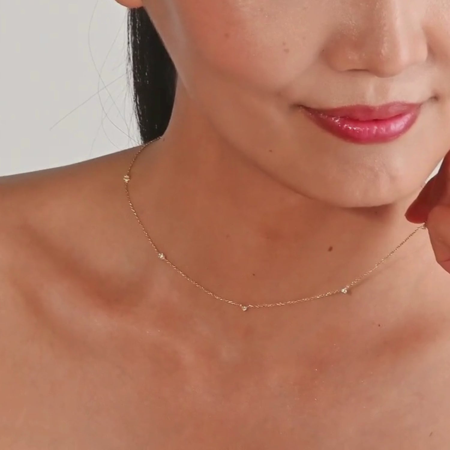 Close-up of a woman wearing a yellow gold bezel diamond necklace, styled with bare shoulders for a minimal look.