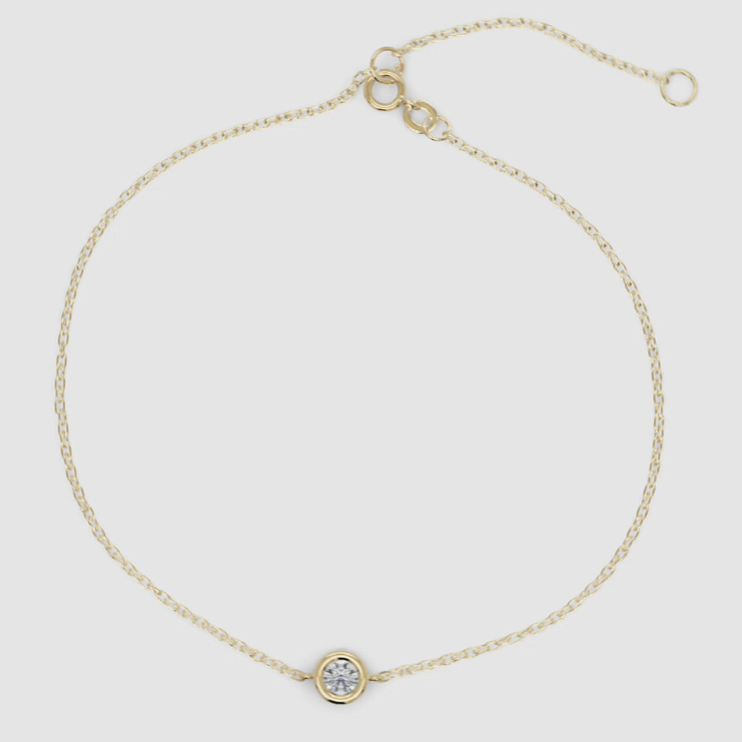 Adjustable bezel-set diamond bracelet in yellow gold displayed flat to show chain details and secure clasp mechanism.

