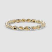 A 360-degree video of a 14k yellow gold twisted diamond eternity band, smoothly rotating to reveal its delicate twisted gold design and sparkling row of round brilliant diamonds from every angle.