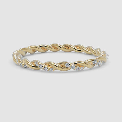A 360-degree video of a 14k yellow gold twisted diamond eternity band, smoothly rotating to reveal its delicate twisted gold design and sparkling row of round brilliant diamonds from every angle.