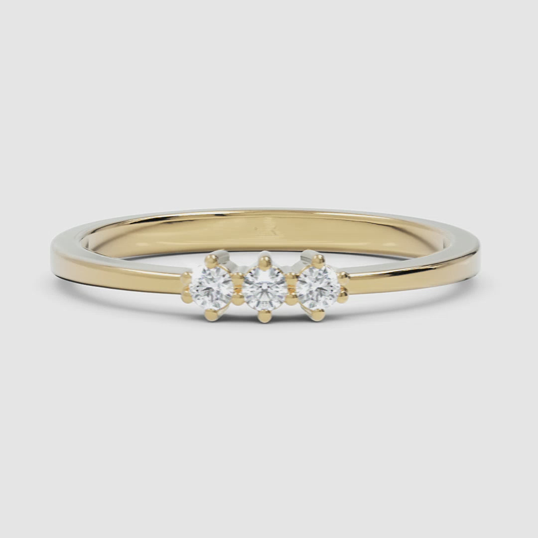 A 360-degree video of a 14k yellow gold three-stone diamond ring, smoothly rotating to reveal its polished gold band and prong-set round diamonds from every angle.