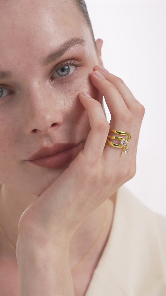 video of a woman with her hand on her face wearing the kyma solitaire rings in solid white gold in 0.50ct, 0.75ct and 1ct sizes on a white background