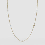Full view of the 14k yellow gold station necklace featuring delicate bezel-set diamonds.