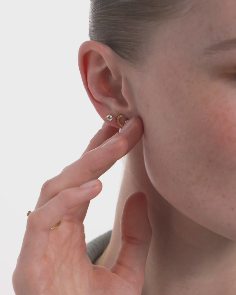 Video of a woman wearing the Selas Diamond Cluster Studs in 14k yellow gold, the seven diamond cluster catching light as she turns her head. ENEA Studio