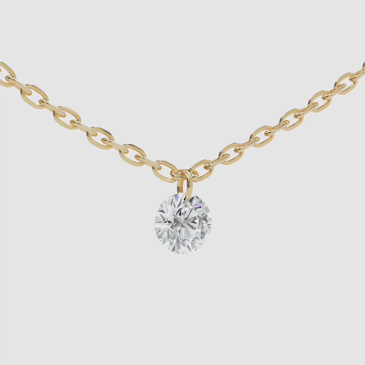 Close-up video of a 14k gold chain necklace featuring a round brilliant-cut diamond solitaire charm, gently swaying left to right.
