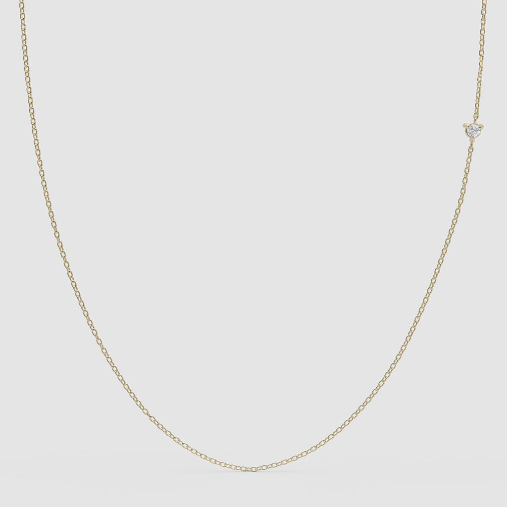 360° view of a minimalist 14k gold chain necklace featuring a small round diamond set off-center, designed to be worn with either side facing forward.

