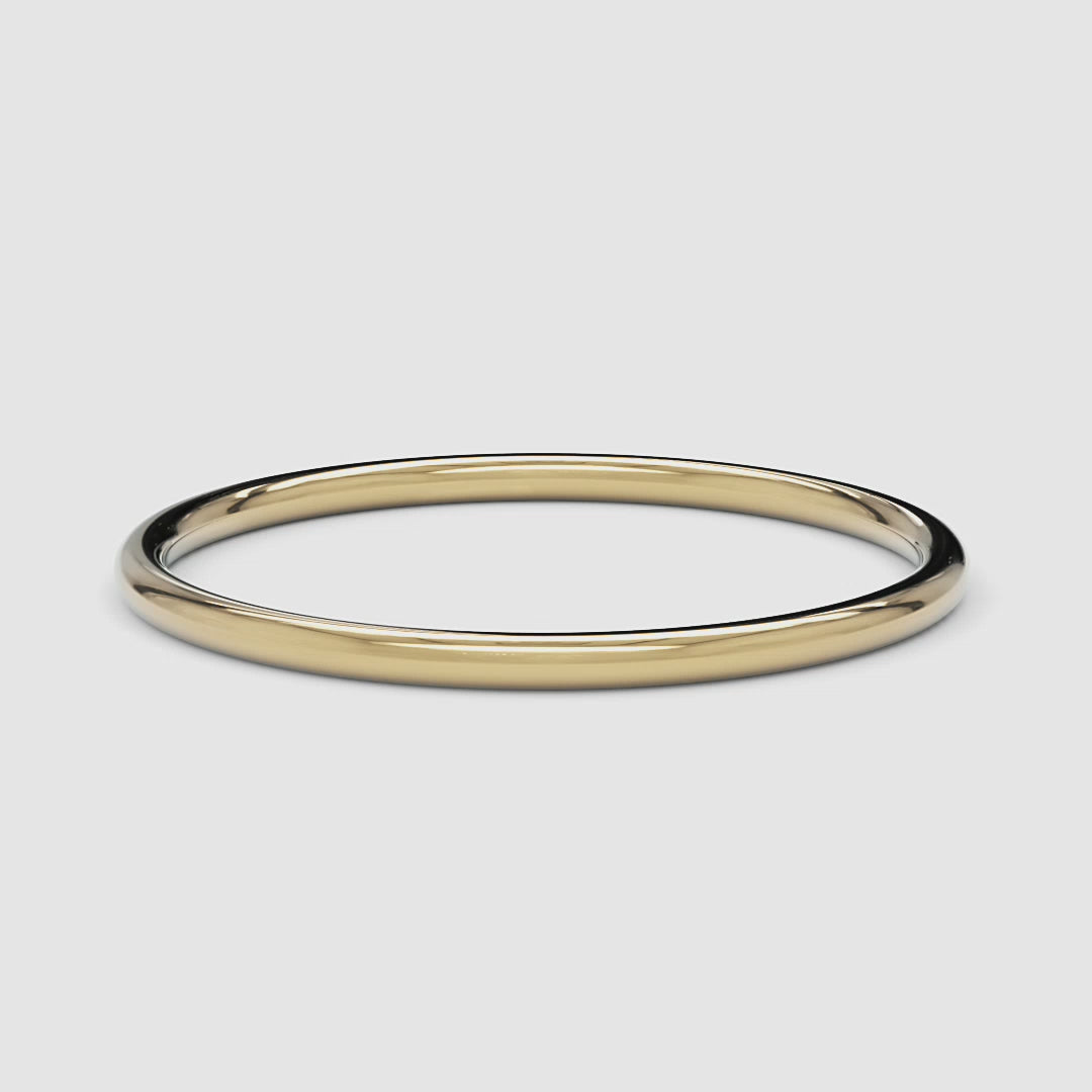 A 360-degree video of a 14k yellow gold thin band, smoothly rotating to reveal its polished, delicate design from every angle.
