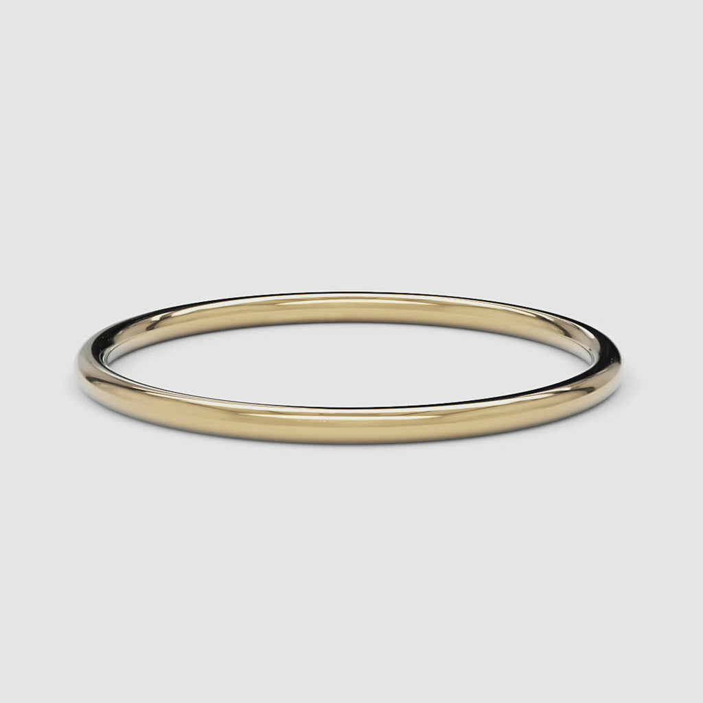 A 360-degree video of a 14k yellow gold thin band, smoothly rotating to reveal its polished, delicate design from every angle.