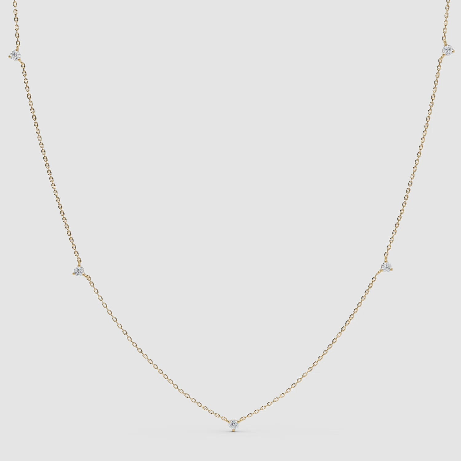 360-degree video of a yellow gold diamond station necklace featuring five small bezel-set diamonds evenly spaced on a fine chain.
