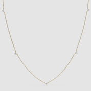 360-degree video of a yellow gold diamond station necklace featuring five small bezel-set diamonds evenly spaced on a fine chain.
