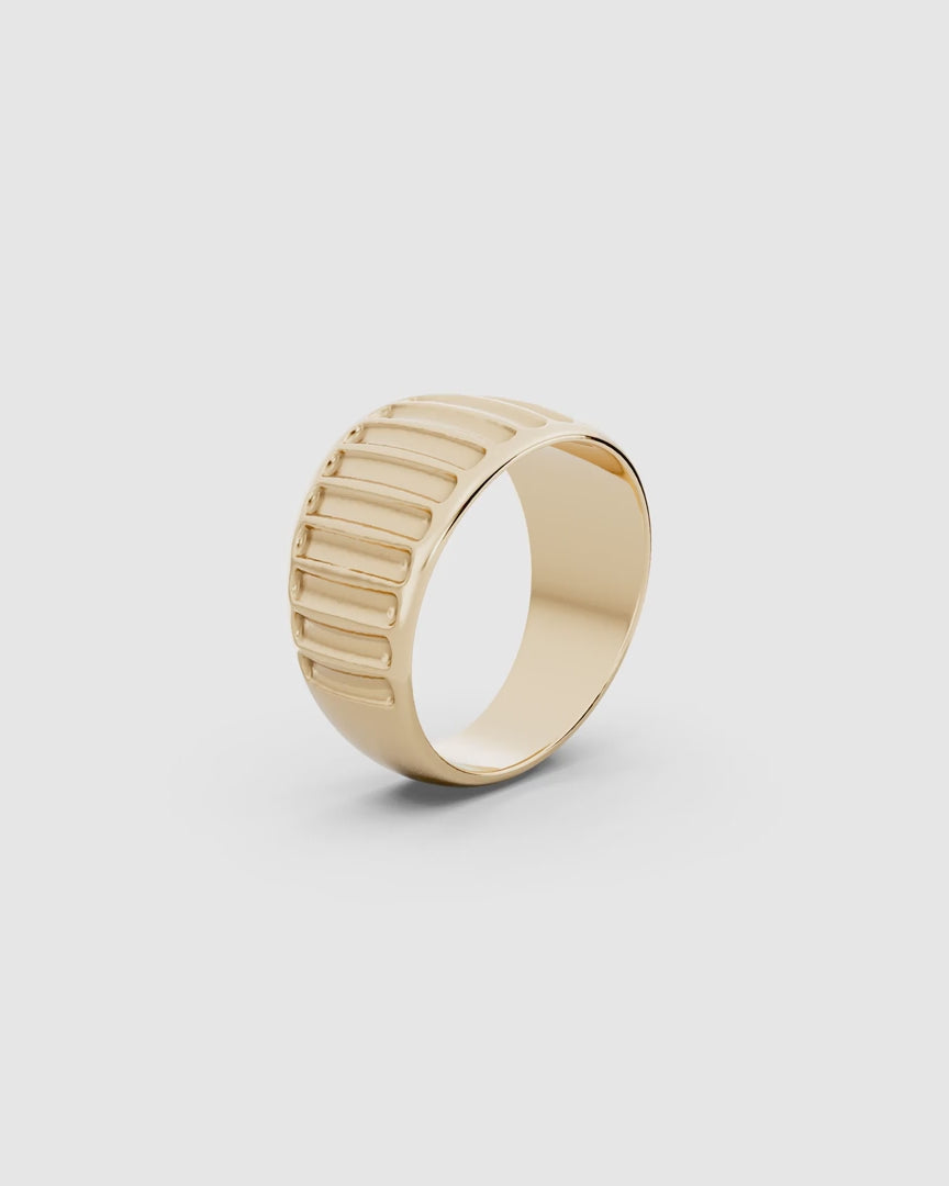 Video giving a 360 view of the Kion Ribbed Dome Ring in yellow gold on a white surface