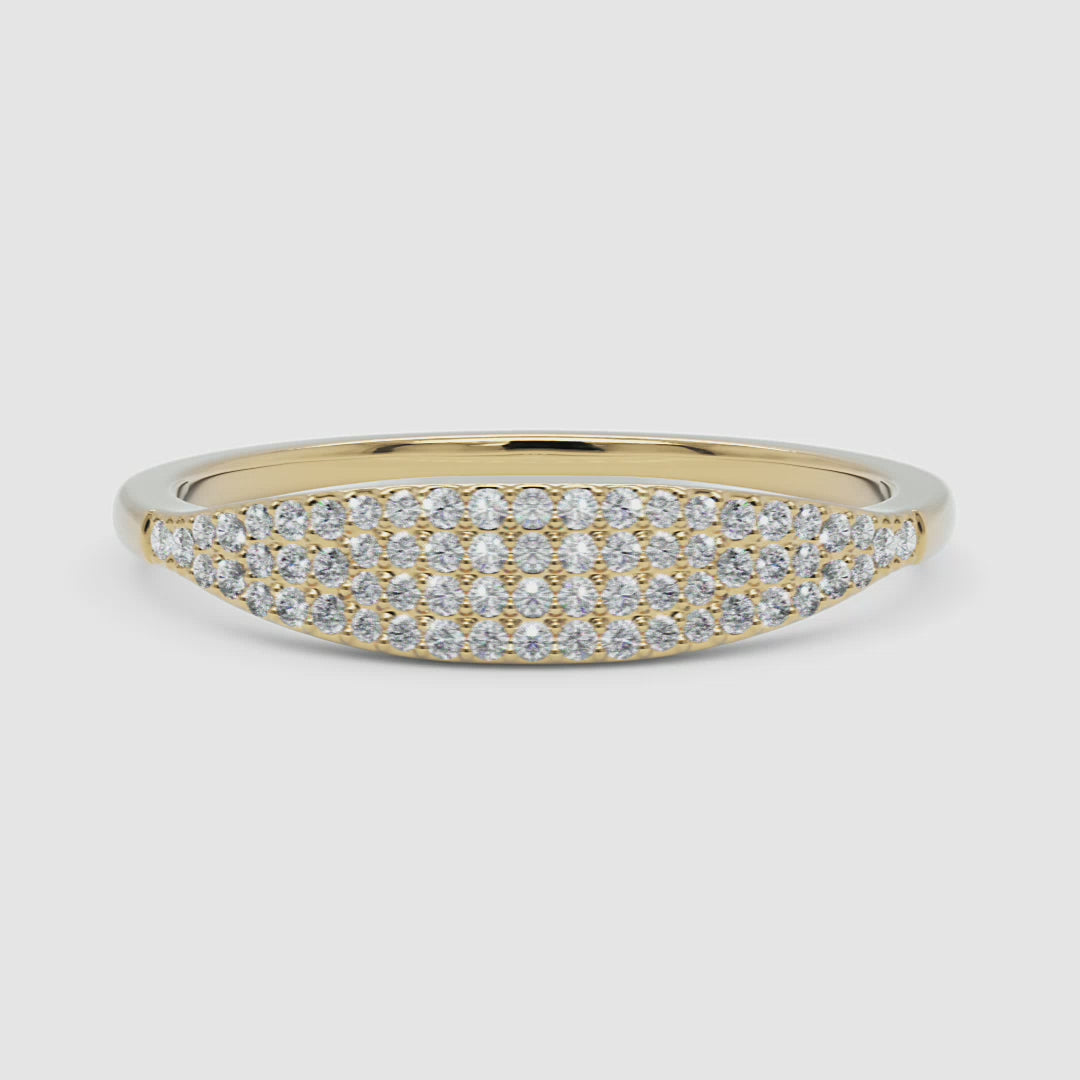  A woman styled with a 14k yellow gold pavé diamond band, showcasing its luxurious diamond detailing and curved silhouette in a natural setting.