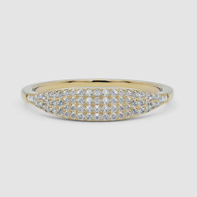  A woman styled with a 14k yellow gold pavé diamond band, showcasing its luxurious diamond detailing and curved silhouette in a natural setting.