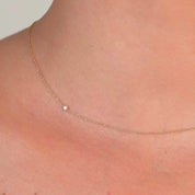 Video of a Close-up side angle of the diamond choker on a model's neck, highlighting the solitaire diamond on the thin gold chain.

