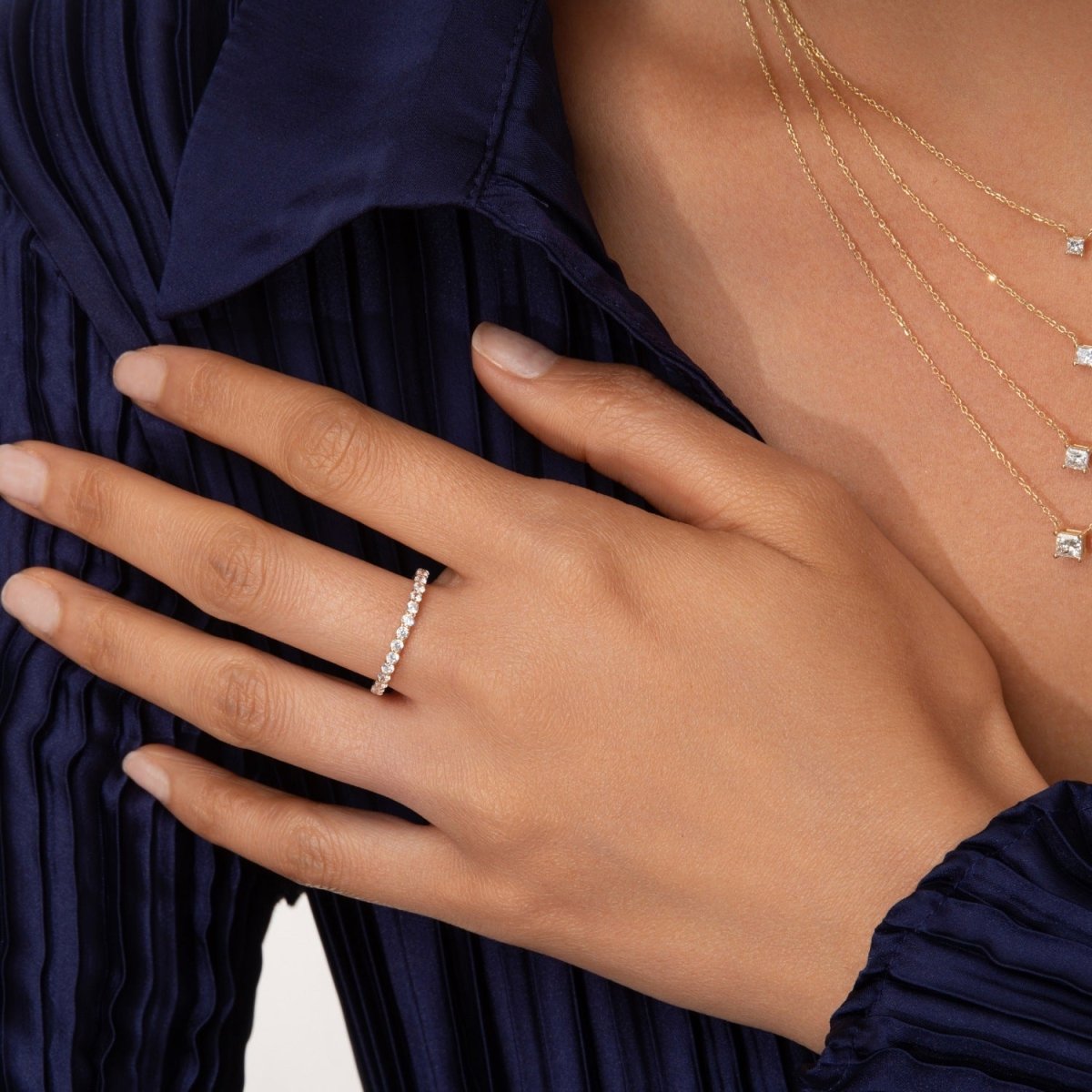model wearing the diamond eternity band on her hand, showcasing its delicate brilliance and perfect stacking appeal
