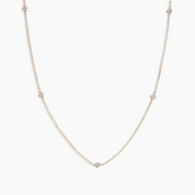 Delicate 14k gold necklace with tiny round-cut diamonds set in a row, minimalist fine jewelry by ENEA
