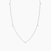 White gold necklace with five small white diamonds evenly spaced along a delicate chain, shown on a plain white background.
