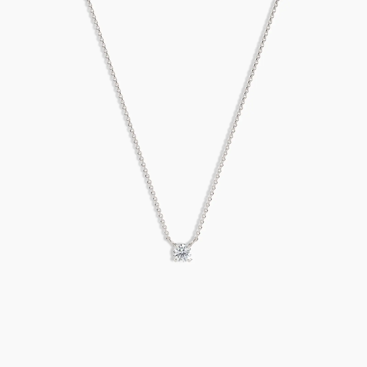 Minimalist white gold solitaire diamond necklace with a round-cut diamond on a delicate chain, shown on a clean white background.
